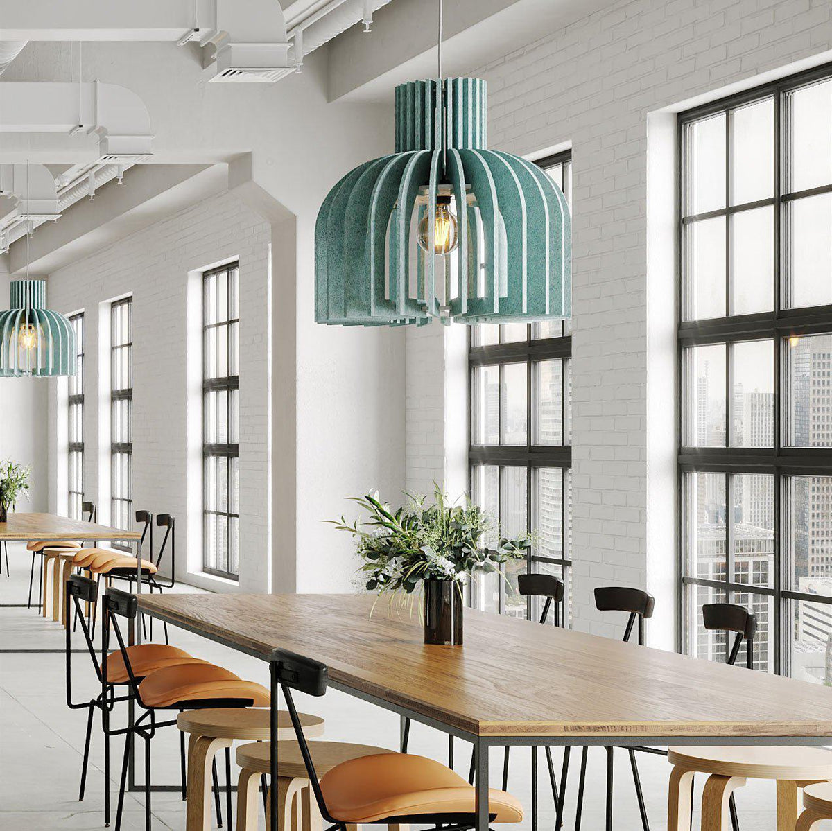 Teal Amien Harmony acoustic pendant lights above a long table in a modern cafe